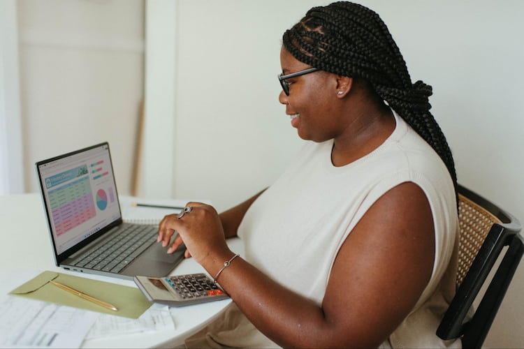women working on a spreadsheet on their computer