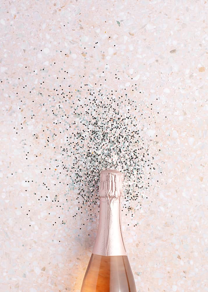 a bottle of champagne and glitter behind it
