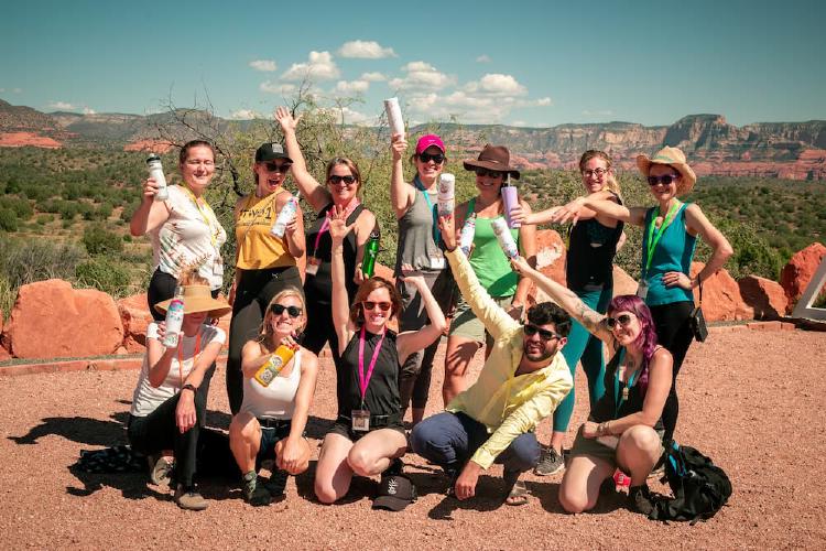 Grant Writing members smile and pose in front of a desert landscape while on a team retreat.